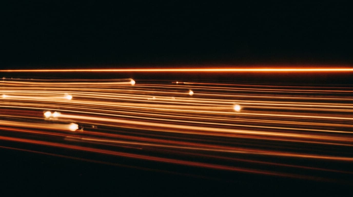 Lignes lumineuses orange parallèles traversant l'obscurité avec des pulses en mouvement